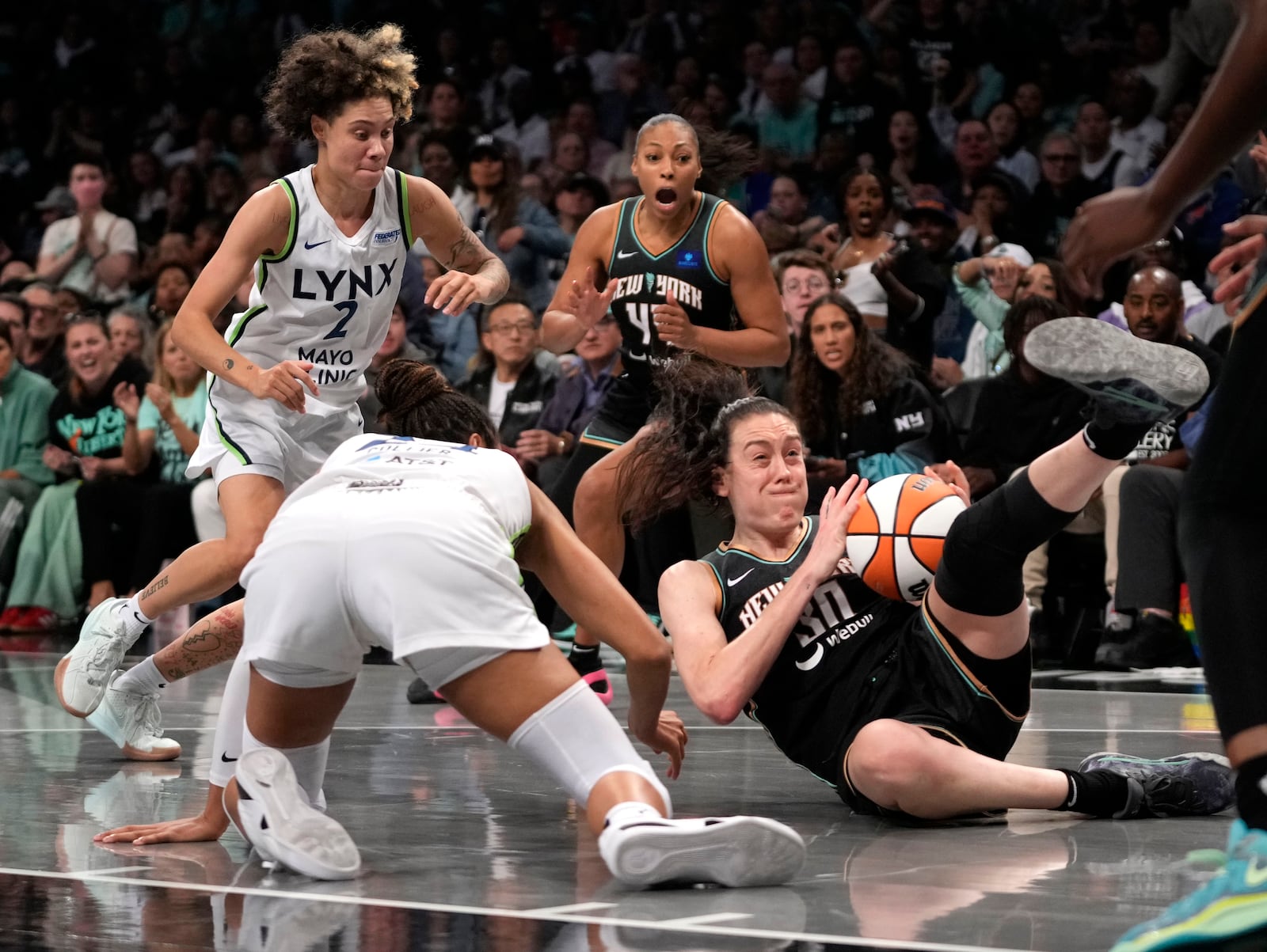 New York Liberty's Breanna Stewart, right, and Minnesota Lynx's Napheesa Collier, front left, fight for the ball during the second half in Game 2 of a WNBA basketball final playoff series, Sunday, Oct. 13, 2024, in New York. (AP Photo/Pamela Smith)