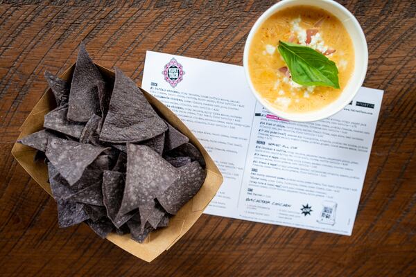 Red Curry Coconut Queso with pickled onion, queso fresco, Thai basil, and blue chips. Photo credit- Mia Yakel.