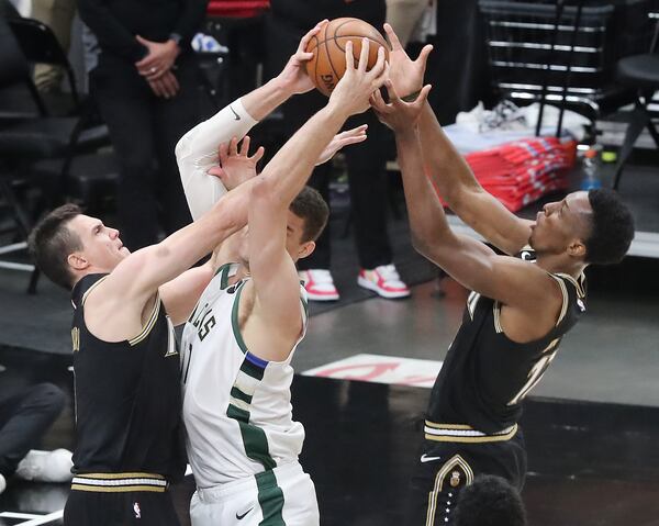 Hawks forwards Danilo Gallinari (left) and Onyeka Okongwu double team Milwaukee Bucks center Brook Lopez.   “Curtis Compton / Curtis.Compton@ajc.com”