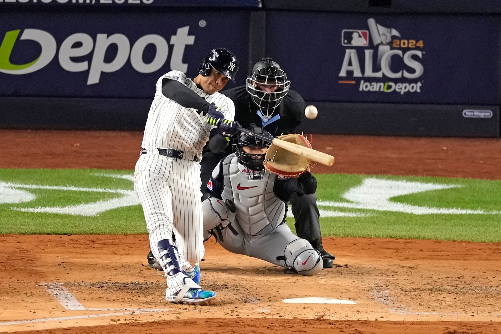 New York Yankees' Juan Soto hits a home run as Cleveland Guardians catcher Bo Naylor reaches for the pitch during the third inning in Game 1 of the baseball AL Championship Series Monday, Oct. 14, 2024, in New York. (AP Photo/Seth Wenig)