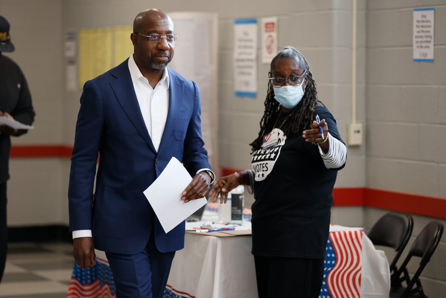 A pool worker gives directions to U.S. Se. Raphael Warnock to indicate where to get his ballot card at the C.T. Martin Rc Center during the first day of early voting of the general elections on Monday, October 17, 2022.Miguel Martinez / miguel.martinezjimenez@ajc.com