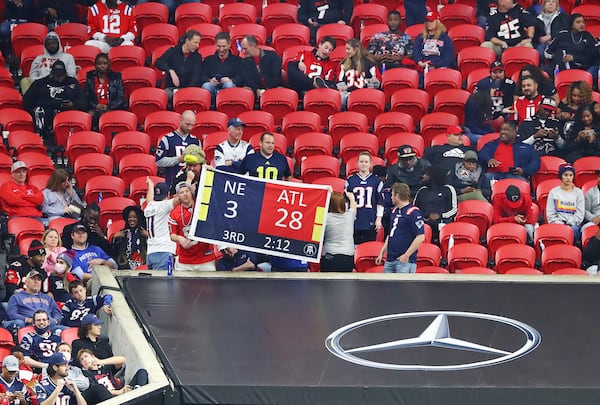 During the Falcons' 25-0 loss to New England on Nov. 18, 2021, Mercedes-Benz Stadium sports many empty seats as Patriots fans hold a sign reminding Falcons fans of their team's blown Super Bowl lead. (Photo by Curtis Compton / Curtis.Compton@ajc.com)