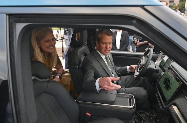 Gov. Brian Kemp and first lady Marty Kemp sit inside a Rivian R1T electric truck during a news conference at Liberty Plaza across from the Georgia State Capitol in Atlanta on Thursday, Dec. 16, 2021. (Hyosub Shin/AJC 2021)