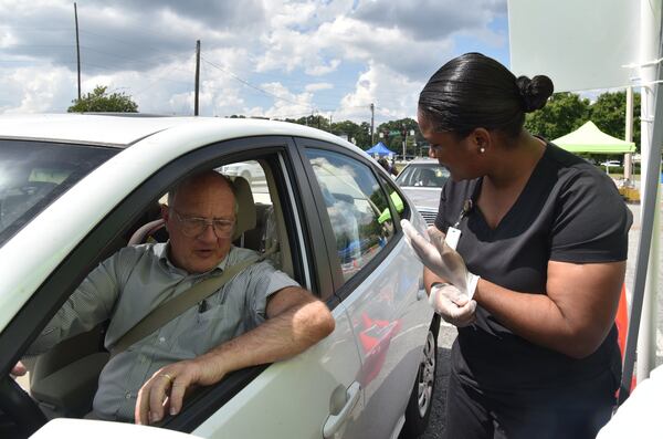 Claudina Prince, a registered nurse with the DeKalb County Board of Health, prepares a flu shot for Tom Keating. HYOSUB SHIN / HSHIN@AJC.COM