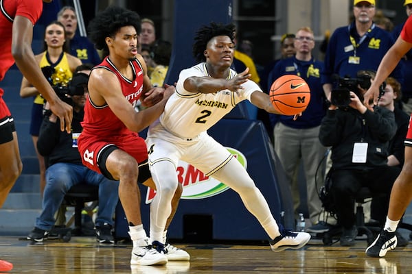 Michigan guard L.J. Cason, right, reaches for a pass in front of Rutgers guard Dylan Harper during the first half of an NCAA college basketball game, Thursday, Feb. 27, 2025, in Ann Arbor, Mich. (AP Photo/Jose Juarez)