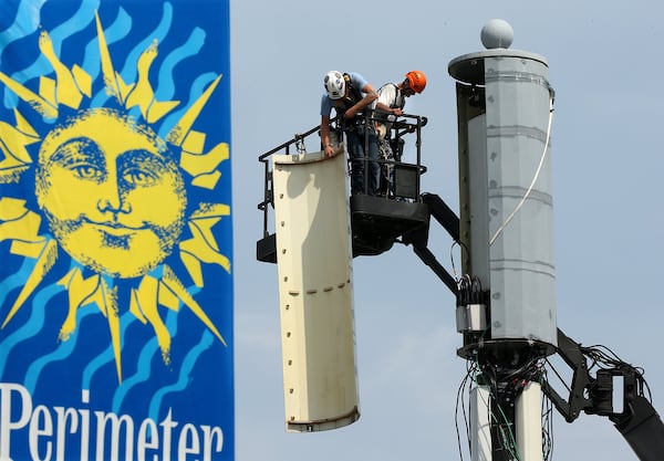 Kyle Niedzwiccki and Ronnie Hatcher with Sky Telecom, work on a bandwidth expansion upgrade on a AT&T cell tower in Perimeter Village off Ashford Dunwoody Road in 2017. (Curtis Compton/ccompton@ajc.com)