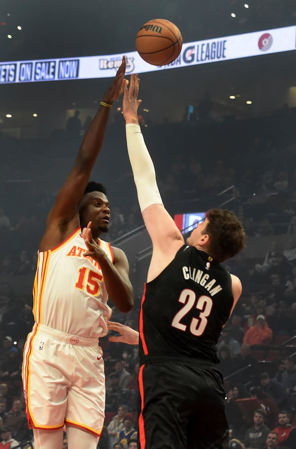 Atlanta Hawks center Clint Capela, left, shoots the ball over Portland Trail Blazers center Donovan Clingan, right, during the first half of an NBA basketball game in Portland, Ore., Sunday, Nov. 17, 2024. (AP Photo/Steve Dykes)