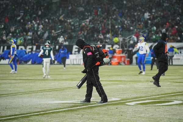 Snow is cleared as the first half ends of an NFL football NFC divisional playoff game between the Philadelphia Eagles and the Los Angeles Rams on Sunday, Jan. 19, 2025, in Philadelphia. (AP Photo/Matt Slocum)