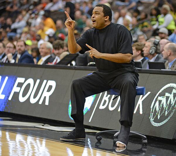 Georgia State head coach Ron Hunter directs his players from a stool on the sidelines during an NCAA tournament round game against Baylor, Thursday, March 19, 2015, in Jacksonville, Fla. Hunter suffered an Achilles injury in celebration of making the tournament.