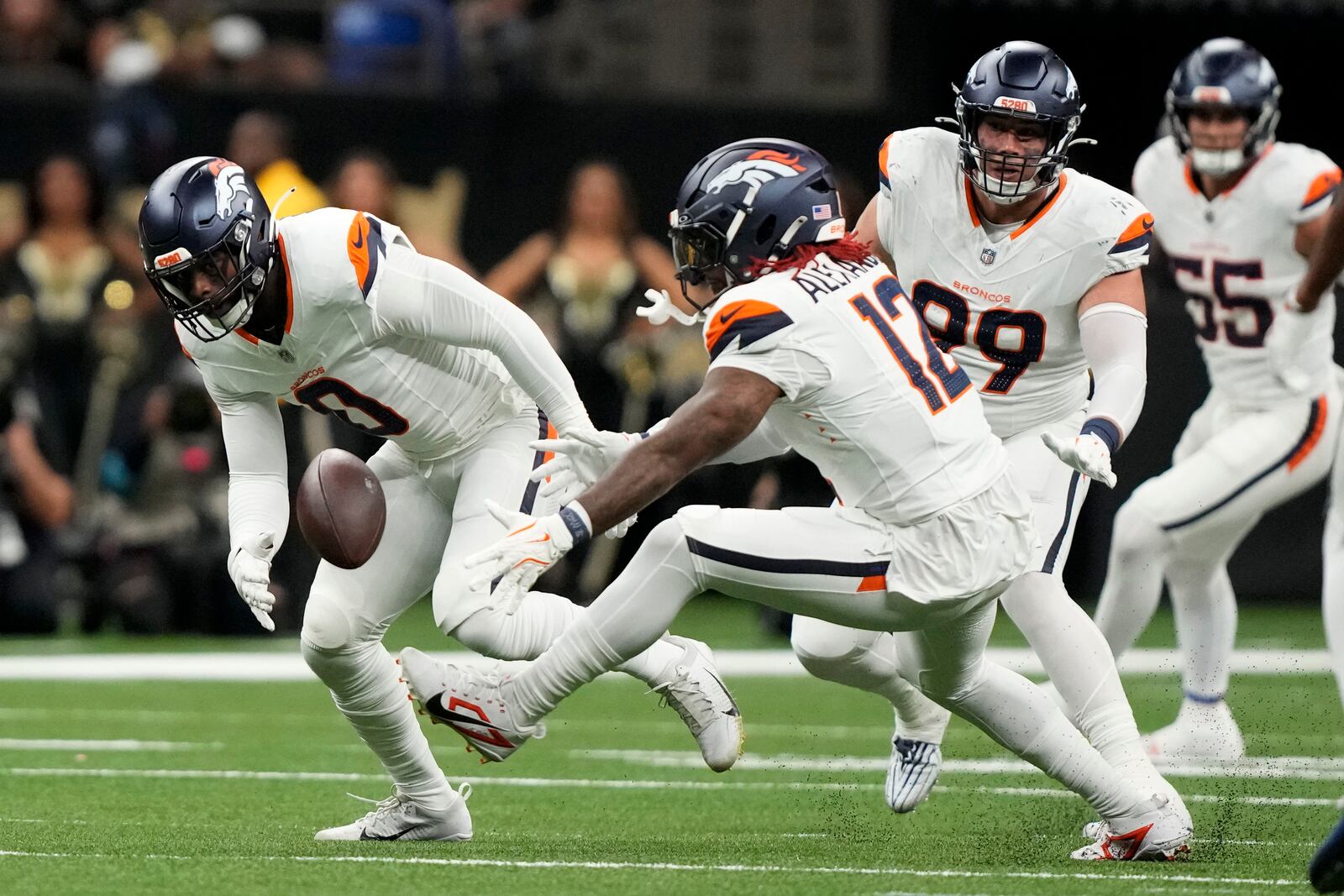 Denver Broncos linebacker Jonathon Cooper (0) and linebacker Kwon Alexander (12) look to recover a fumble during the first half of an NFL football game against the New Orleans Saints, Thursday, Oct. 17, 2024, in New Orleans. (AP Photo/Gerald Herbert)