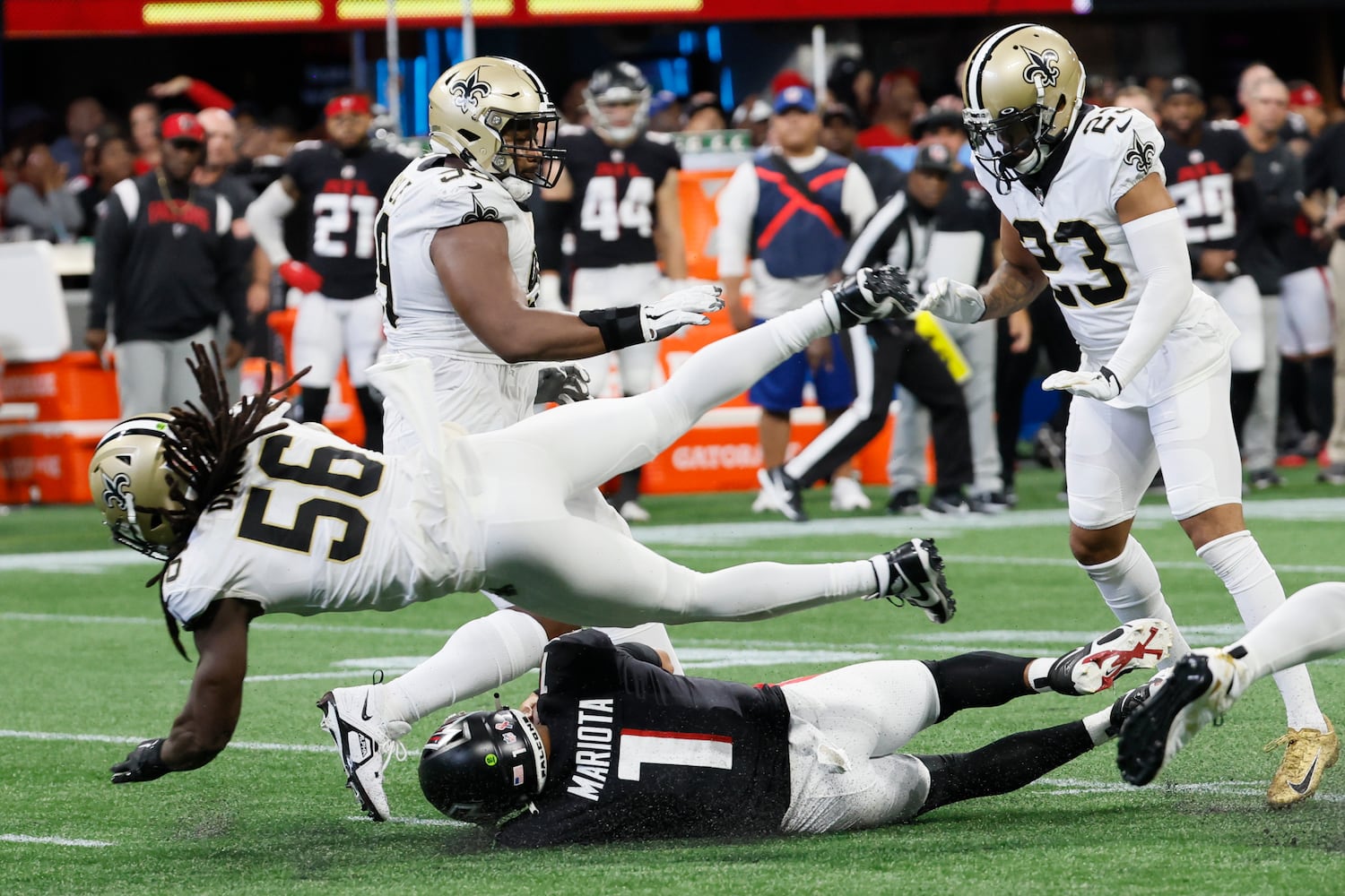 Falcons quarterback Marcus Mariota slides as Saints linebacker Demario Davis pursues during the fourth quarter Sunday. (Miguel Martinez / miguel.martinezjimenez@ajc.com)