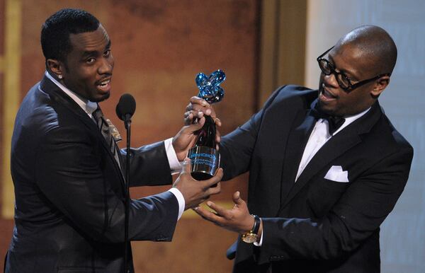 FILE - In this Jan. 16, 2010 file photo, media executive Andre Harrell, right, presents an award to Sean "Diddy" Combs at the Warner Theatre during the 2010 BET Hip Hop Honors in Washington. Harrell, the Uptown Records founder who shaped the sound of hip-hop and R&B in the late 80s and 90s with acts like Mary J. Blige and Heavy D and also launched the career of mogul Sean “Diddy” Combs, has died, several members of the music community revealed late Friday, May 8, 2020. He was 59. (AP Photo/Nick Wass)