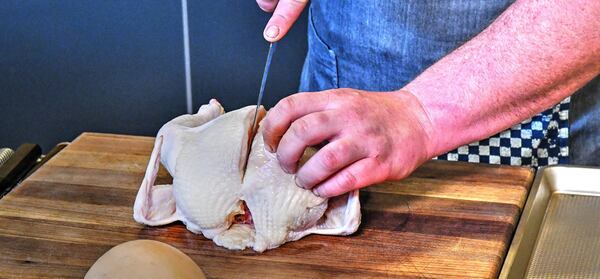 Oak Steakhouse executive chef Travis Kirkley shows proper use of a boning knife on a whole chicken. CONTRIBUTED BY CHRIS HUNT PHOTOGRAPHY