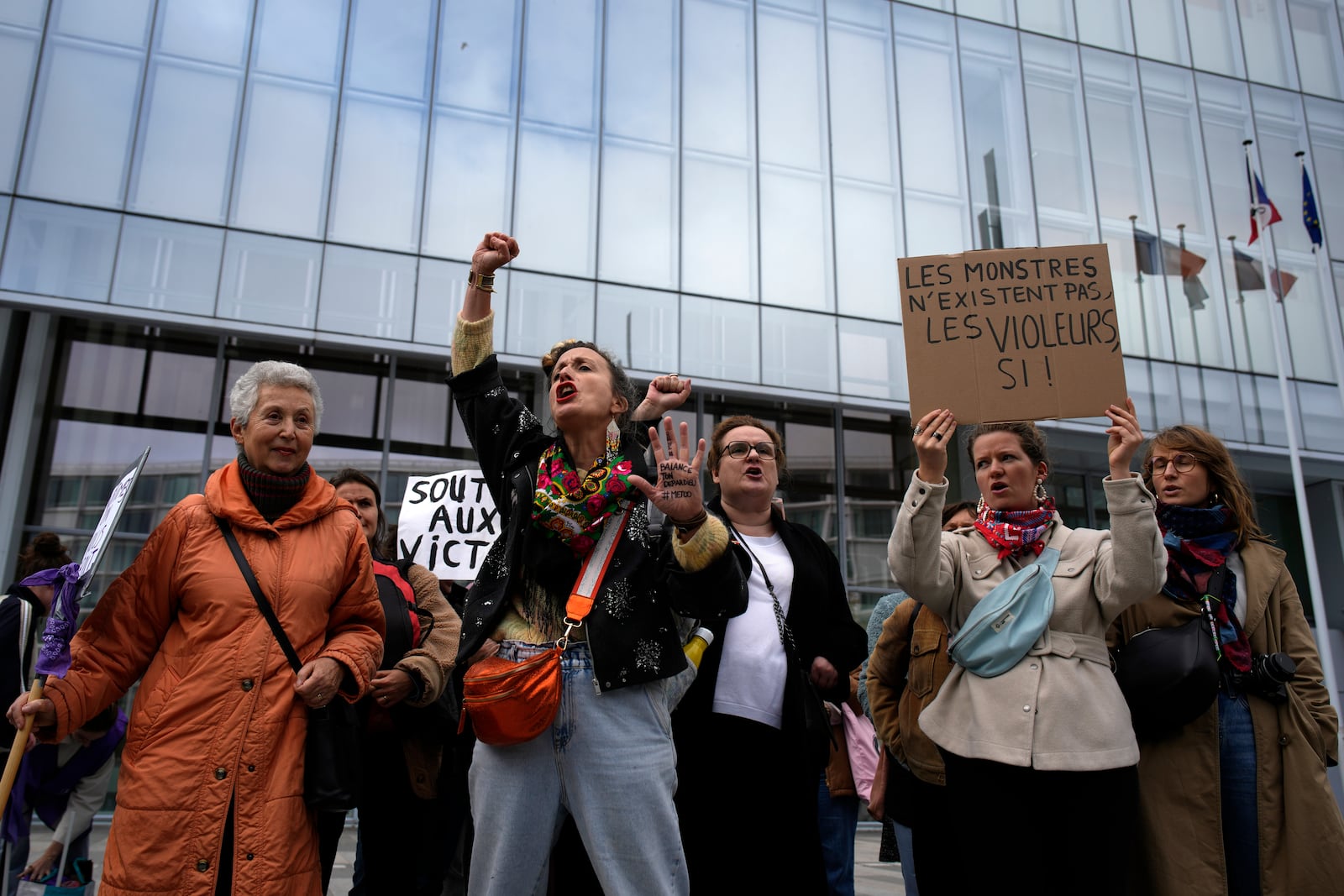 Women's rights activists demonstrate outside the Paris palace of justice as French actor Gérard Depardieu, who is facing trial for the alleged sexual assaults of two women on a film set in 2021, won't appear before a criminal court, Monday, Oct. 28, 2024 in Paris. (AP Photo/Louise Delmotte)