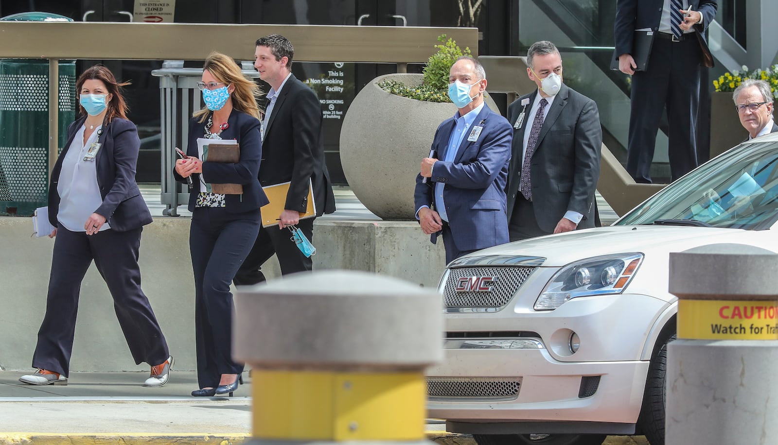 A group of masked individuals leave the Georgia World Congress Center on Monday, April 13, 2020. Gov. Brian Kemp announced on Easter Sunday, April 12, that the state will convert part of the sprawling Georgia World Congress Center into a 200-bed hospital for coronavirus patients. JOHN SPINK/JSPINK@AJC.COM