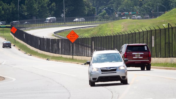 Cars drive by some of the 29.5 miles of fence that surround the Hartsfield-Jackson Atlanta International Airport July 10, 2018. STEVE SCHAEFER / SPECIAL TO THE AJC