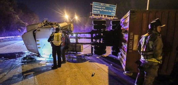  In March, an overturned tractor trailer blocked most lanes of I-85 north of the airport during morning rush hour. It's unclear if any such mishaps on U.S. roadways involved truckers falsely certified by chiropractor Anthony Lefteris. JOHN SPINK /JSPINK@AJC.COM