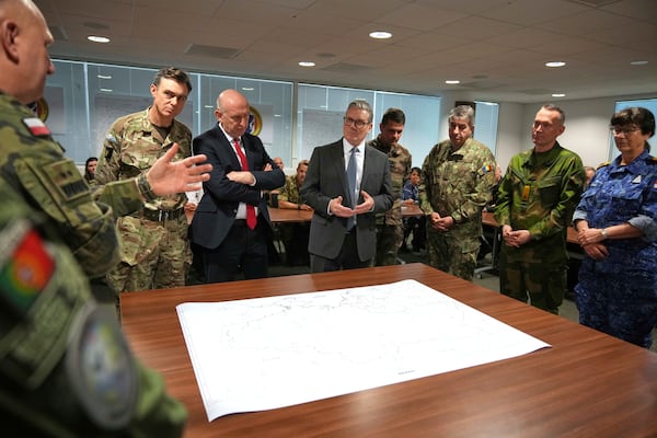 Britain's Prime Minister Keir Starmer and John Healey, Secretary of State for Defence, center left, listen as they visit a military base to meet planners mapping out next steps in the Coalition of the Willing in Greater London, Thursday, March 20, 2025.(AP Photo/Alastair Grant, Pool)