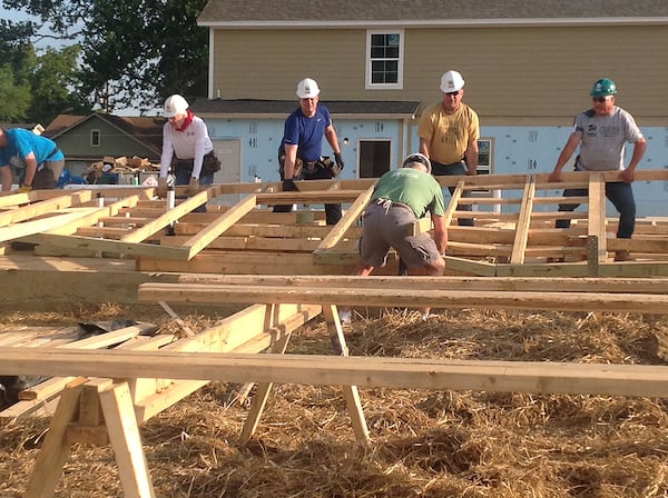 2016 (Memphis): Former President Jimmy Carter (left, white shirt) and Garth Brooks (gold shirt) help raise a wall on the first day of a weeklong Habitat for Humanity build in Memphis last August. (JILL VEJNOSKA / Jill.Vejnoska@ajc.com)