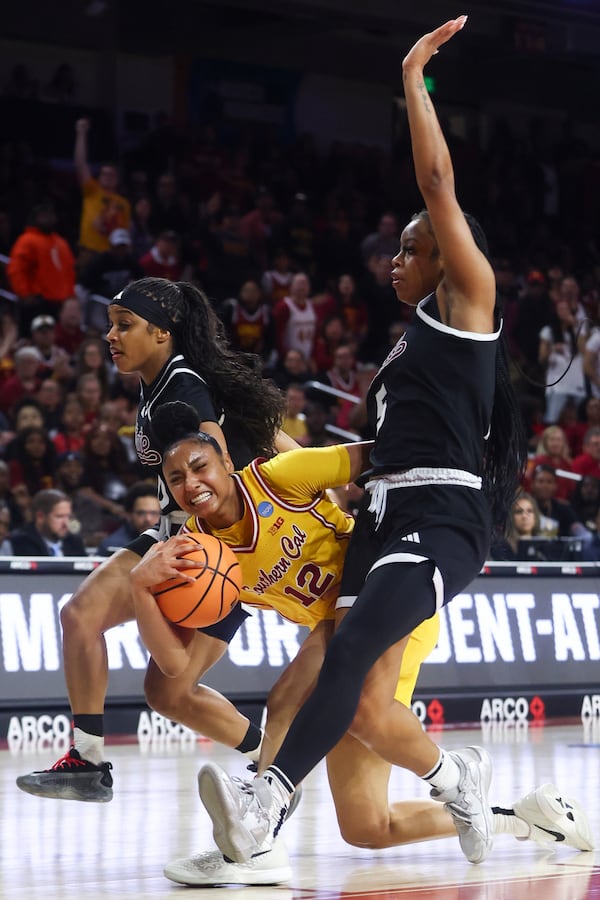 Southern California guard JuJu Watkins (12) draws a foul against Mississippi State guard Eniya Russell, left, and guard Chandler Prater (5) during the first half in the second round of the NCAA college basketball tournament Monday, March 24, 2025, in Los Angeles. (AP Photo/Jessie Alcheh)