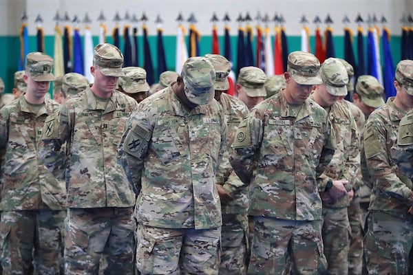 Members of the Georgia National Guard’s 48th Brigade pray during a departure ceremony at Fort Stewart. Curtis Compton/ccompton@ajc.com