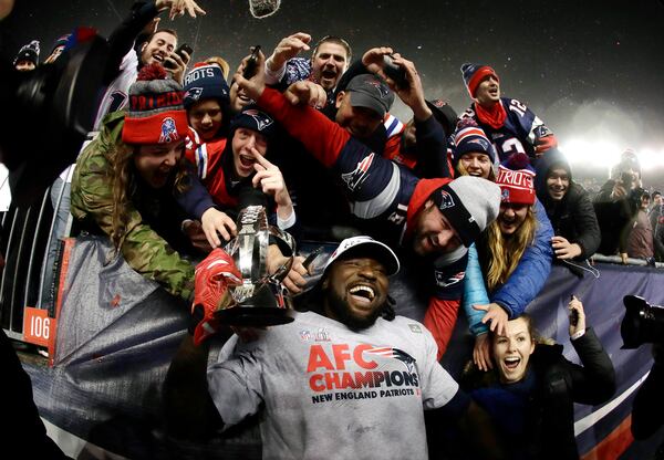 New England Patriots running back LeGarrette Blount holds the AFC championship trophy surrounded by fans after the AFC championship NFL football game, Sunday, Jan. 22, 2017, in Foxborough, Mass. The Patriots defeated the the Pittsburgh Steelers 36-17 to advance to the Super Bowl.Ê(AP Photo/Matt Slocum)