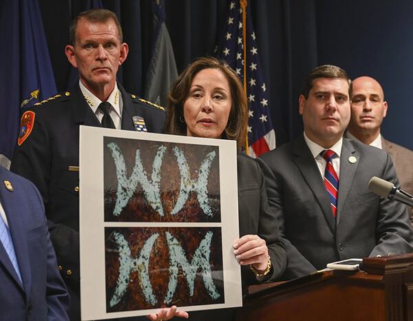 Suffolk County Police Commissioner Geraldine Hart shows a photograph with the initials on a belt, showing either an HM or WH, depending on the angle, during a press conference at police headquarters in Yaphank , N.Y. on Jan. 16, 2020.