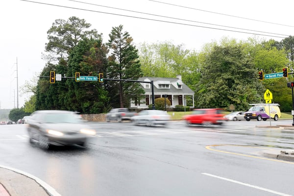 The McAfee home is the only house visible between commercial buildings at the corner of Bells Ferry Road and Barrett Parkway in Cobb County. 
Miguel Martinez /miguel.martinezjimenez@ajc.com
