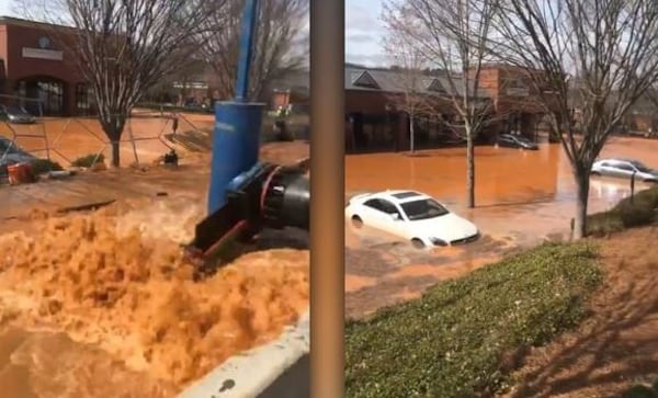 A broken water main sent muddy water flooding into this shopping center parking lot near Fariburn and Cascade roads on Monday. Several patrons were unable to reach their cars for hours.