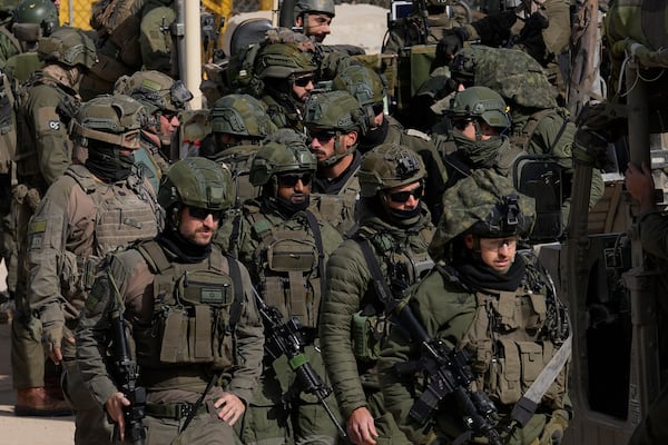 Israeli soldiers stand next to armoured vehicles before crossing the security fence, moving towards the so-called Alpha Line that separates the Israeli-controlled Golan Heights from Syria, in the town of Majdal Shams, Thursday, Dec. 12, 2024. (AP Photo/Matias Delacroix)