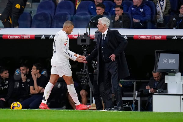 Real Madrid's head coach Carlo Ancelotti, right, and Real Madrid's Kylian Mbappe greet each other during a substitution at the Spanish La Liga soccer match between Real Madrid and Rayo Vallecano at the Santiago Bernabeu stadium in Madrid, Spain, Sunday, March 9, 2025. (AP Photo/Manu Fernandez)