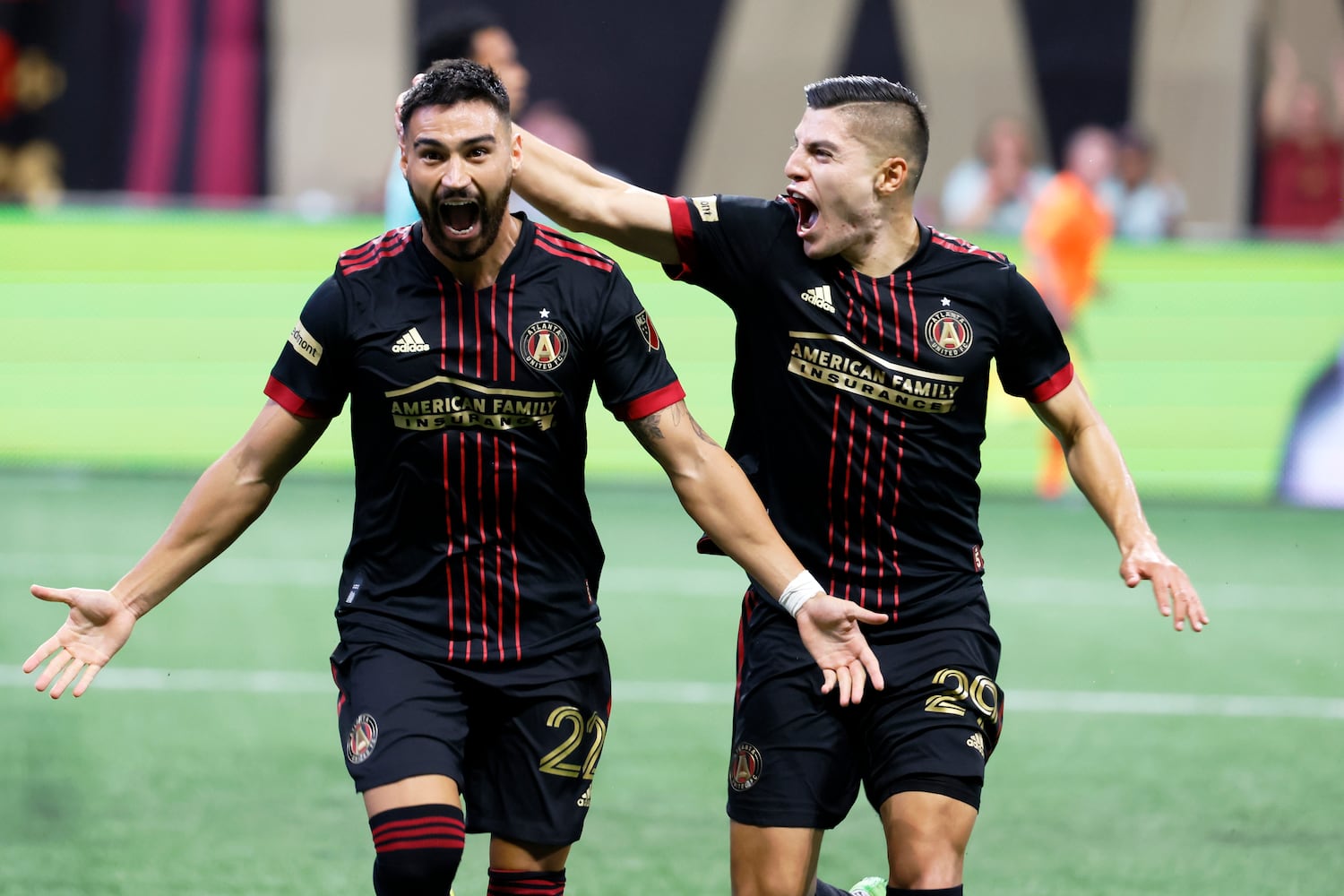 Atlanta United's Ronaldo Cisneros (29) celebrates with Juan Jose Purata after Purata scored the team's first goal against Orlando on Sunday at Mercedes-Benz Stadium. (Miguel Martinez /Miguel.martinezjimenez@ajc.com)