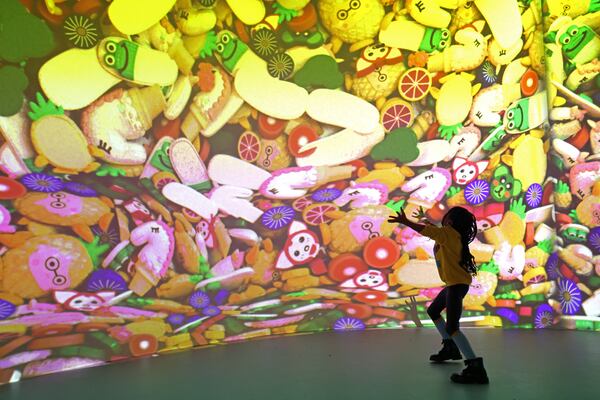 Seven-year-old Navali Barnes, of McDonough, plays projection rooms in the slime-filed experience of Sloomoo in Buckhead, Wednesday, November 16, 2022, in Atlanta. Jason Getz / Jason.Getz@ajc.com)