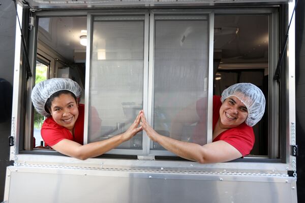 Mrs. Rosa Foods founders Maria Rosal (left) and Zaimar Castillo (right) pose inside their food truck. With two years in the market, they have grown as much as in producing cheeses and typical Venezuelan dishes. 
Miguel Martinez / miguel.martinezjimenez@ajc.com