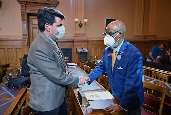 Rep. Chuck Efstration (R-Dacula), left, and Rep. Calvin Smyre (D-Columbus) shake hands as they wait for a press conference after HB 426 passed the House on day 37 of the legislative session at Georgia State Capitol on Tuesday, June 23, 2020. HB-426 passed. The bill would implement stiffer penalties if those guilty of crimes are found to have been motivated by hate. (Hyosub Shin / Hyosub.Shin@ajc.com)