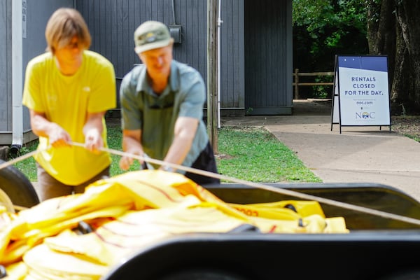 (left to right) Andrew Nichols, head guide and Daniel Mills, the assistant manager at Nantahala Outdoor Center put deflated rafting tubes on a truck in front of a closed sign on Monday,  July 3, 2023. An 11-mile stretch of the Chattahoochee River sustained sewage spilling from Fulton County’s Big Creek Water Reclamation over the weekend. (Natrice Miller/ Natrice.miller@ajc.com)