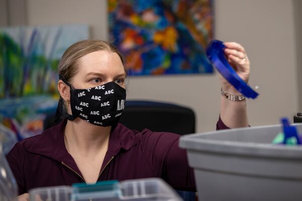 Skyler Holobach, co-founder of Atlanta Shield Makers, pieces together a face shield at Roswell Firelabs in Roswell. (Alyssa Pointer / Alyssa.Pointer@ajc.com)