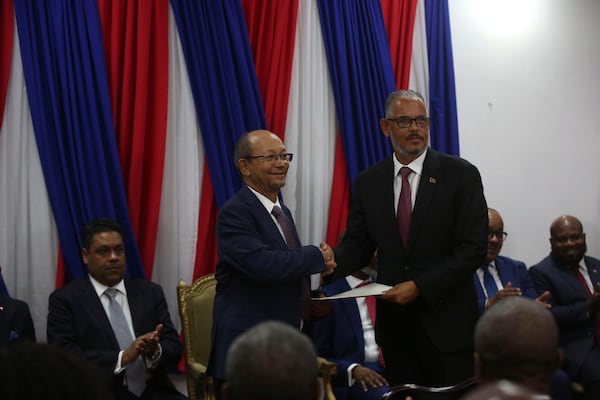 Haiti's new Prime Minister Alix Didier Fils-Aimé, right, shakes hands with Transition Council President Leslie Voltaire during his swearing-in ceremony in Port-au-Prince, Haiti, Monday, Nov. 11, 2024. (AP Photo/Odelyn Joseph)