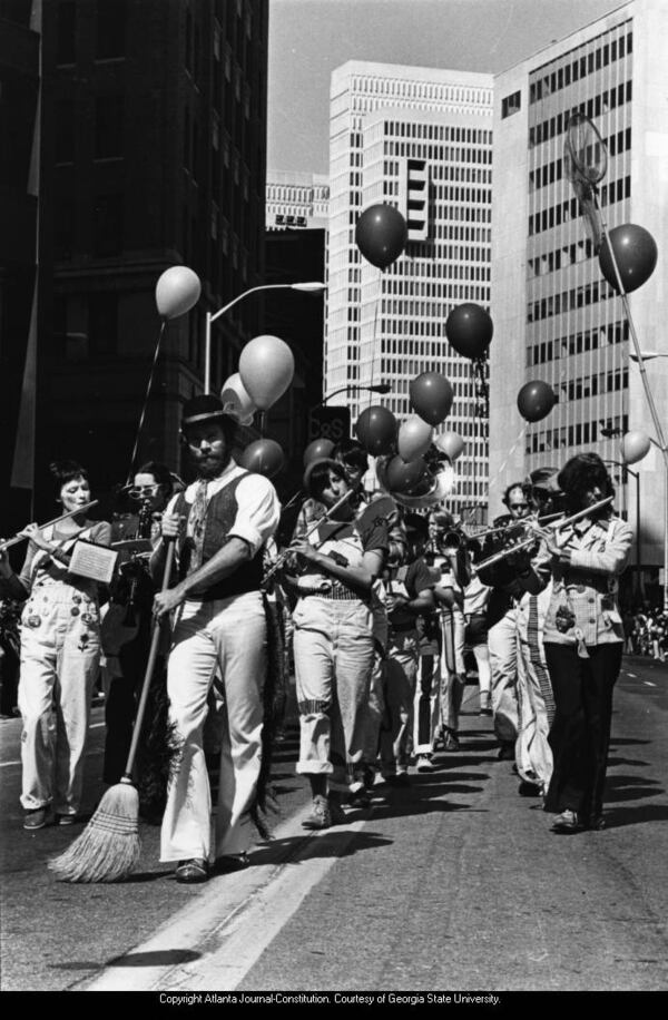 March 16, 1980 -- The original caption for this photo was "Wearin' the Green Again: A merry band of Irish folk does a little bit of cleanup on Peachtree Street Saturday as Atlantans get ready for St. Patrick's Day Monday. Better known around town as Kelley's Feed and Seed Marching Band, these entertainers, from flutists to broom pusher, were among the many groups marching in the weekend parade." JUDY ONDREY / AJC PHOTO ARCHIVES