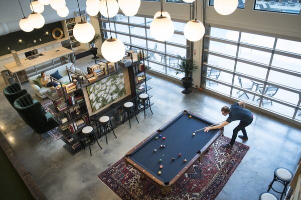 Matthew Clark is pictured inside the Olmsted Chamblee where he lives. The new apartment complex features public spaces designed to appeal to young professionals. (John Amis Special for the AJC)