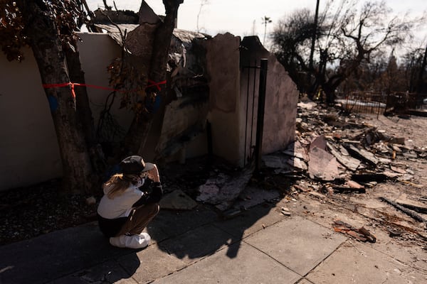 Eaton Fire evacuee Ceiba Phillips, 11, is overwhelmed with emotion as he visits his best friend's home, which was devastated by the fire, across the street from his own in Altadena, Calif., Saturday, Feb. 8, 2025. (AP Photo/Jae C. Hong)