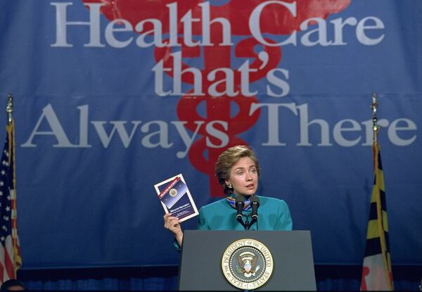 In this Thursday, Oct. 28, 1993 file photo, first lady Hillary Clinton, holds a copy of the Clinton health care plan as she kicks off a campaign at Johns Hopkins University in Baltimore, Md. (AP Photo/Joe Marquette)