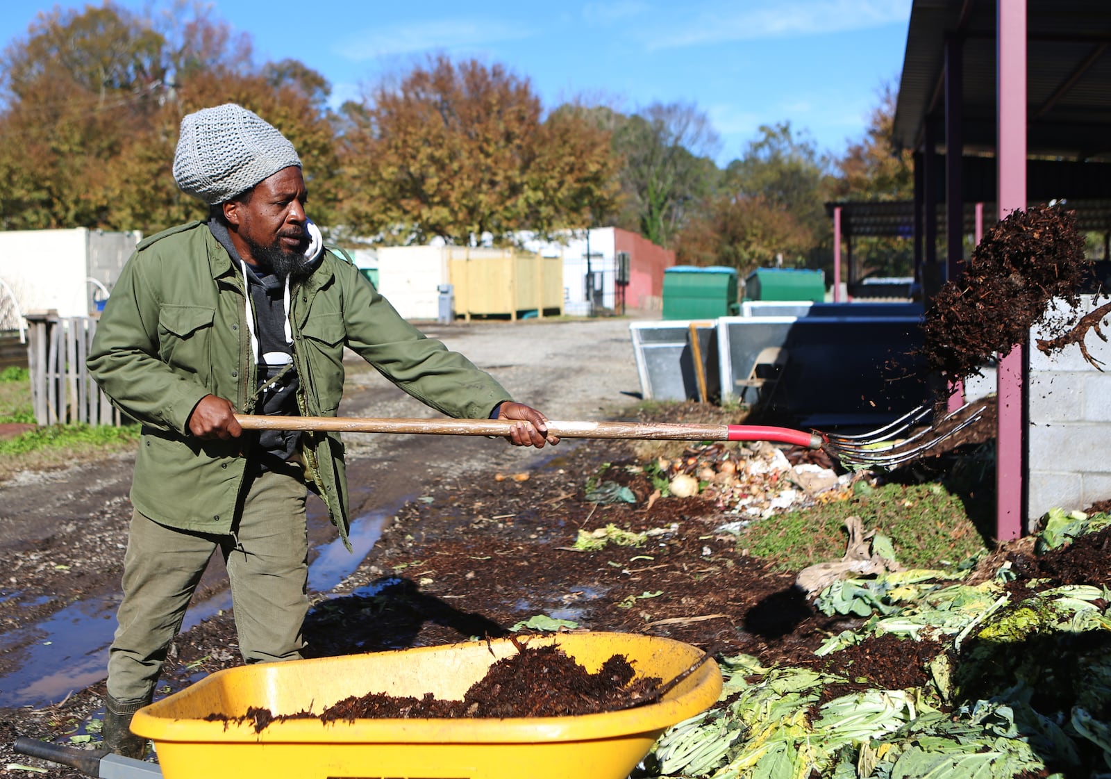 At the Truly Living Well center, produce is grown in raised beds. They generate soil for those beds in several enormous compost piles, where leaves and decaying vegetable matter are transformed into loam. Otis Garrison, farm manager, shovels mulch. CHRISTINA MATACOTTA FOR THE ATLANTA JOURNAL-CONSTITUTION