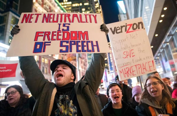 FILE - In this Thursday, Dec. 7, 2017 file photo, Demonstrators rally in support of net neutrality outside a Verizon store in New York. Consumers arenât likely to see immediate changes following Monday, June 11, 2018 formal repeal of Obama-era internet rules that had ensured equal treatment for all. Rather, any changes are likely to happen slowly, and companies will try to make sure that consumers are on board with the moves, experts say. (AP Photo/Mary Altaffer, File)