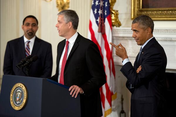 President Barack Obama, right, reacts to remarks by Education Secretary Arne Duncan, in the State Dining Room of the White House in Washington, Friday, Oct. 2, 2015, during an announcement in which Duncan said he will be stepping down in December after 7 years in the Obama administration. Duncan will be returning to Chicago and Obama has appointed senior Education Department official, John King Jr., left, to oversee the Education Department. (AP Photo/Manuel Balce Ceneta)