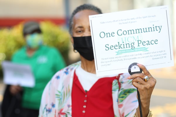 Vernell Smith holds a sign during the stop the violence vigil outside of the Golden Glide skating rink.