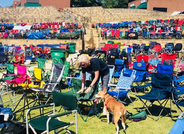 Debbie Taylor and dog Stella finally find a spot to put down chairs on Friday, Sept. 7, the day before a 38 Special concert in the Park at City Center in Woodstock. Part of the free summer concert series put on by the city, the show drew some 15,000 people -- many of whom had started marking their spots with chairs the Tuesday before. (Jill Vejnoska/AJC)