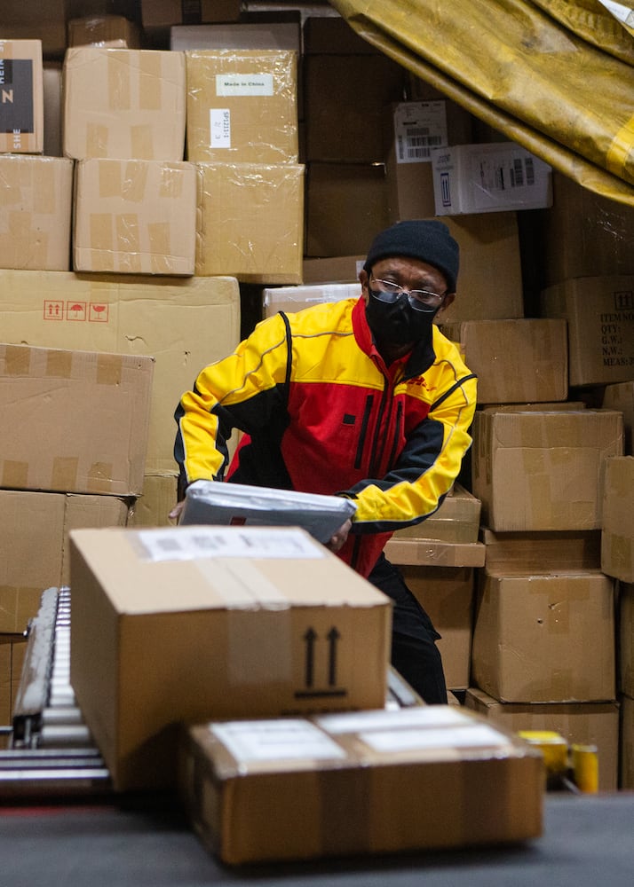 Willie Gurerra sorts packages on Wednesday, December 16, 2020, at DHL Express in Atlanta. Workers at the shipping center worked to fulfill orders during the holiday rush. CHRISTINA MATACOTTA FOR THE ATLANTA JOURNAL-CONSTITUTION.