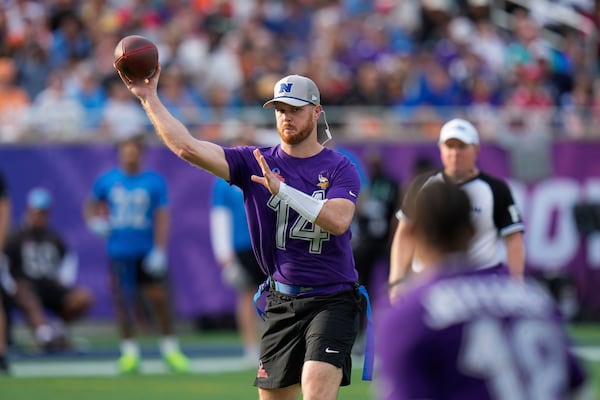 NFC quarterback Sam Darnold (14), of the Minnesota Vikings, throws a touchdown to wide receiver Justin Jefferson, of the Minnesota Vikings, foreground, during the flag football event at the NFL Pro Bowl, Sunday, Feb. 2, 2025, in Orlando. (AP Photo/Chris O'Meara)