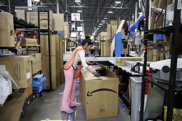 A worker fills boxes to ship at an Amazon fulfillment center in Romeoville, Illinois, August 1, 2017. (Brian Cassella/Chicago Tribune/TNS)